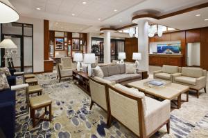 a living room with couches and tables and chairs at Hilton Garden Inn Portland Downtown Waterfront in Portland