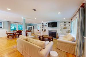 a living room with two couches and a fireplace at Lewis Bay Getaway in West Yarmouth