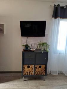 a black dresser with a flat screen tv on a wall at RockBeach bungalow in Costa Teguise