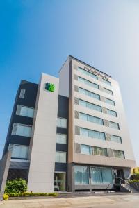 Un edificio alto con una señal verde. en Palmetto Hotel Business San Miguel en Lima