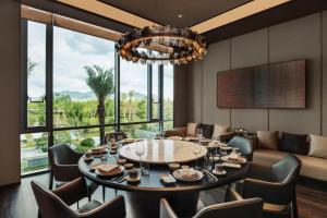 een eetkamer met een tafel en stoelen en een kroonluchter bij Sheraton Taizhou in Taizhou