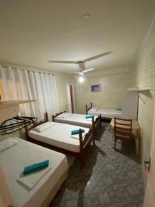 um quarto com três camas num quarto em Pousada nascente do sol em Macaé