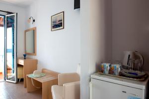 a room with a kitchen with a table and a mirror at Hotel Kyma in Skala Eresou