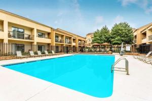 a swimming pool in a courtyard with chairs and a building at Comfort Inn Roswell-Dunwoody in Roswell