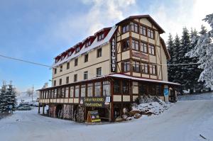 un gran edificio en la nieve delante en Absolwent, en Duszniki-Zdrój