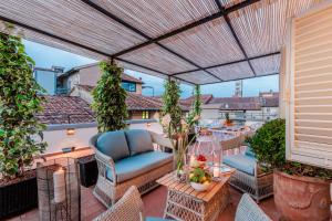 a patio with chairs and tables on a balcony at Toscana Lucca centro attico esclusivo con grande terrazza panoramica in Lucca