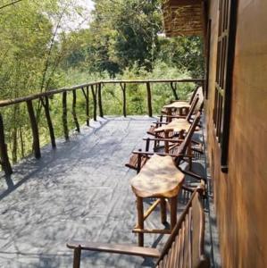 una fila di panche di legno sedute su un balcone di Milla Resort a Buttala