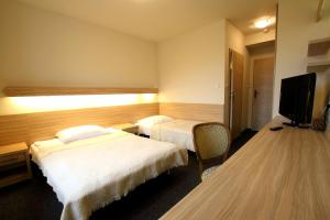 a hotel room with two beds and a flat screen tv at Absolwent in Zieleniec
