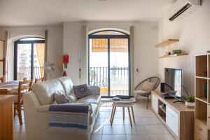 - un salon avec un canapé et une télévision dans l'établissement 2BD Cosy Apartment with Spacious Balcony - Close to Bugibba Beach, à San Pawl il-Baħar