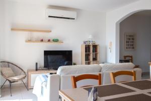 - un salon avec un canapé blanc et une télévision dans l'établissement 2BD Cosy Apartment with Spacious Balcony - Close to Bugibba Beach, à San Pawl il-Baħar