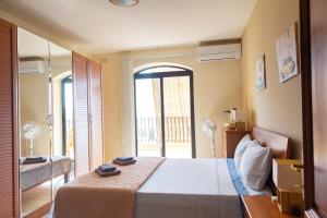 - une chambre avec un grand lit et une grande fenêtre dans l'établissement 2BD Cosy Apartment with Spacious Balcony - Close to Bugibba Beach, à San Pawl il-Baħar