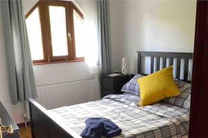 a bedroom with a bed with a yellow pillow and a window at Water view Apartment in Belfast