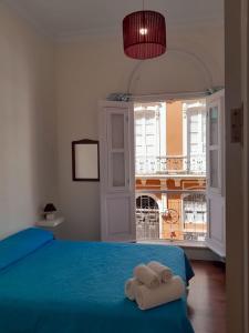 1 dormitorio con 2 toallas en una cama con ventana en Old town Santa Cruz, en Santa Cruz de Tenerife