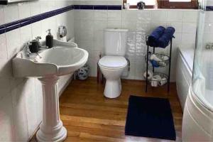 a bathroom with a sink and a toilet and a tub at Water view Apartment in Belfast