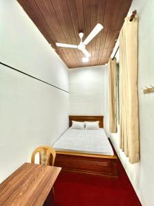 a small bedroom with a bed and a table at KINGS HOTEL in Colombo