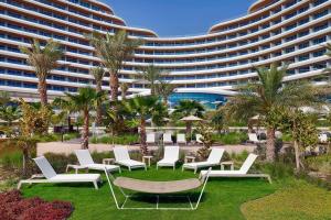 a resort with white chairs and a large building at Waldorf Astoria Lusail, Doha in Doha