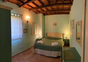 a bedroom with a green bed and a window at Borgo Di Fonni in Sellano