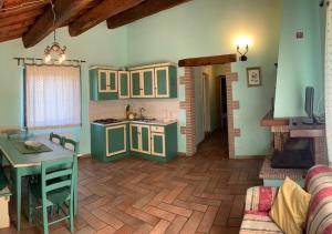 a kitchen with green cabinets and a table in a room at Borgo Di Fonni in Sellano