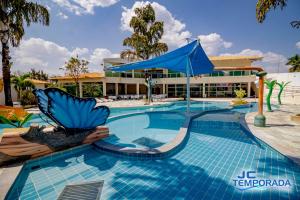 un complejo con piscina con sombrilla azul en diRoma Internacional Resort, en Caldas Novas