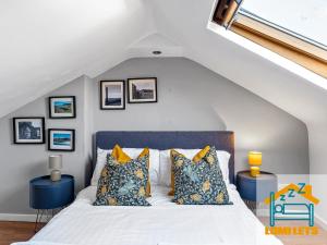 um quarto com uma cama com almofadas azuis e amarelas em 2BR Home In Barrow-in-Furness Sleeps 8 close to BAE Systems, Hospital, Lakes em Barrow in Furness