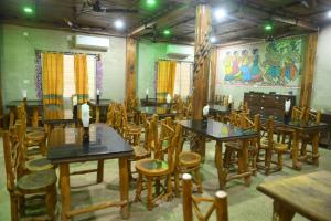 サンティ・ニケタンにあるRam Shyam Village Resortのテーブルと椅子が備わる壁画のある部屋