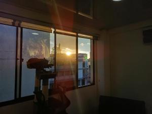 a room with a window with a view of the sunset at Amplia Habitación En El Cable in Manizales