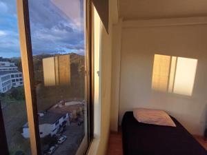 a bedroom with a window with a view of a city at Amplia Habitación En El Cable in Manizales