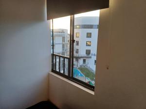 a window in a room with a view of a building at Amplia Habitación En El Cable in Manizales