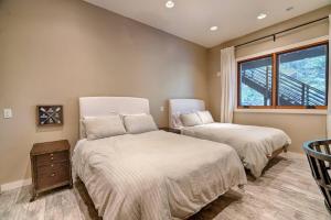 1 dormitorio con 2 camas y ventana en The Chic Cabin Apartment, en Flagstaff