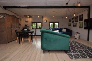a living room with a green couch and a table at Apartament w ,chlewiku” in Gołdap