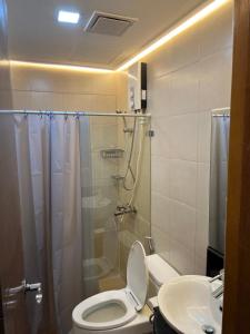 uma casa de banho com um WC, um chuveiro e um lavatório. em Morgan Suites Executive Residences em Manila