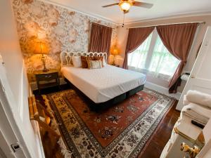 a bedroom with a bed and a window and a rug at Park Place Inn and Cottages in Sanford