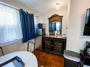 Habitación con cocina con fregadero y espejo. en Park Place Inn and Cottages en Sanford