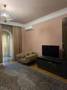 a living room with a flat screen tv and a couch at Josefin Apartment in Yerevan