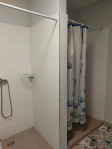 a shower stall with a shower curtain in a bathroom at Pigus apgyvendinimas Palangoje in Palanga