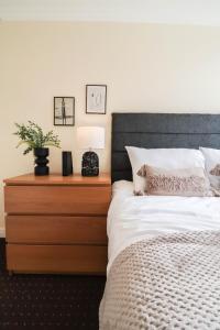 ein Schlafzimmer mit einem Bett und einer Holzkommode in der Unterkunft Cosy property right by WARREN STREET station! FREE WIFI! in London