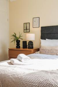 ein Schlafzimmer mit einem Bett mit zwei Handtüchern darauf in der Unterkunft Cosy property right by WARREN STREET station! FREE WIFI! in London
