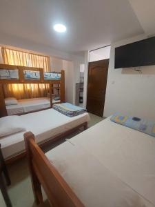 a bedroom with two beds and a flat screen tv at R. A. C. S. in Paracas