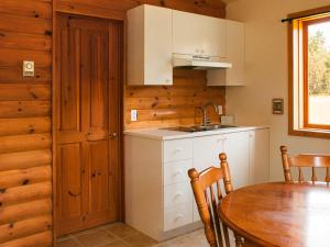 una cucina con tavolo, lavandino e porta di Kilomètre 42 a Val-David