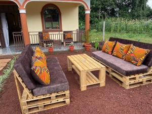 two couches and a coffee table on a patio at Home Feeling Kilimanjaro in Moshi