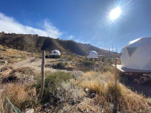 a view of two domes and a boat in a field at Domos Andinos HostCamp in Potrerillos