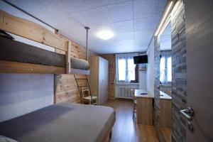 a bedroom with a bed and a desk and a sink at Livigno Vista panoramica .Casa. in Livigno