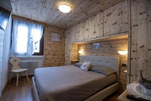 a bedroom with a bed and a wooden wall at Livigno Vista panoramica .Casa. in Livigno