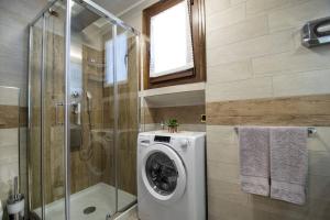a bathroom with a washing machine and a shower at Livigno Vista panoramica .Casa. in Livigno