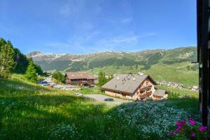 a house on the side of a grassy hill at Livigno Vista panoramica .Casa. in Livigno