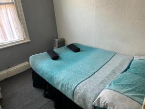 1 dormitorio con cama con sábanas azules y ventana en Adina Hotel, en Blackpool