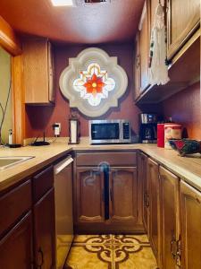 La cuisine est équipée de placards en bois, d'un évier et d'un four micro-ondes. dans l'établissement The Casita in the heart of Paradise Valley Arizona, à Scottsdale