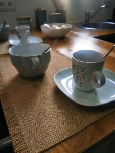 a table with a bowl and a cup on a plate at Le Cocon d'Aurore in Reims