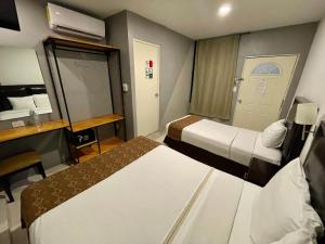 a hotel room with two beds and a desk at He Centro - Desayuno incluido in Tuxtla Gutiérrez