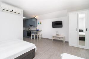 um quarto branco com uma cama e uma cozinha em Apartment Lavanda em Kruševo